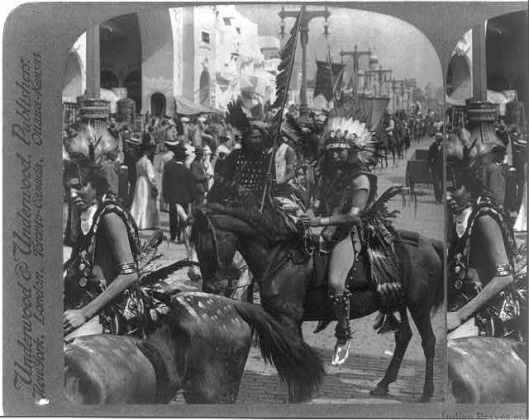 Indian braves, splendid with savage finery, riding their ponies